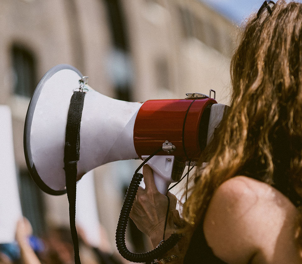 Woman speaking into megaphone at disability advocacy event