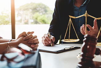 Close-up of lawyer talking to client with scales on the table between them