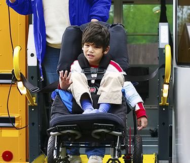 Young boy on a school bus wheelchair lift