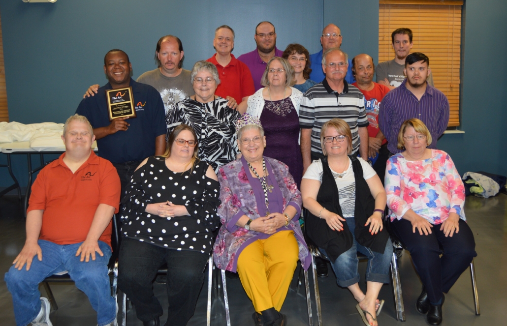 A large group of people sits and stands posing for a photo. 