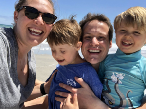 A man, Burt Hudson, at the beach with his wife and two young children